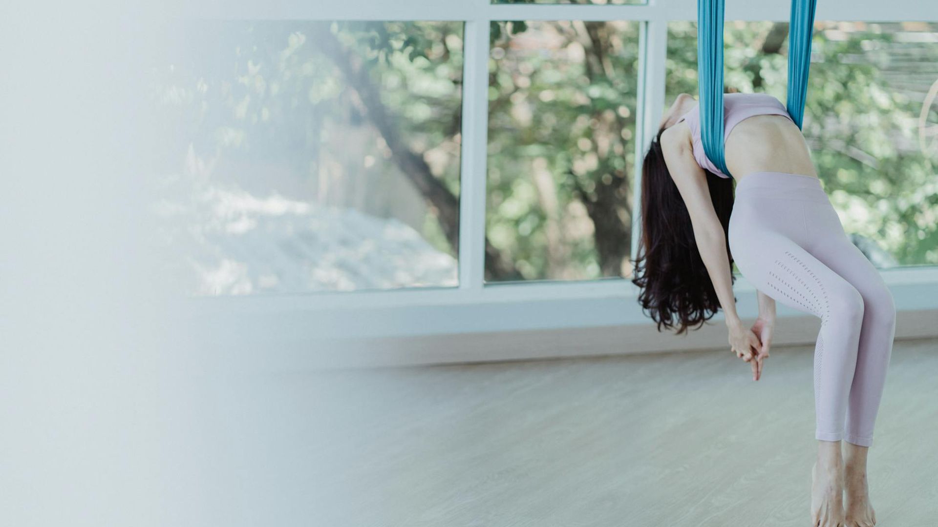 Serene woman practicing gentle yoga flow in a bright studio.